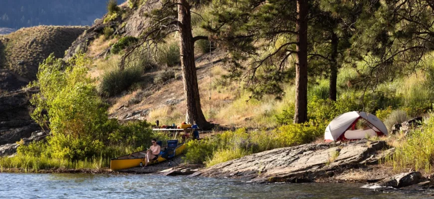 Scenic lakeside camping in Okanagan Valley with mountains and pine trees
